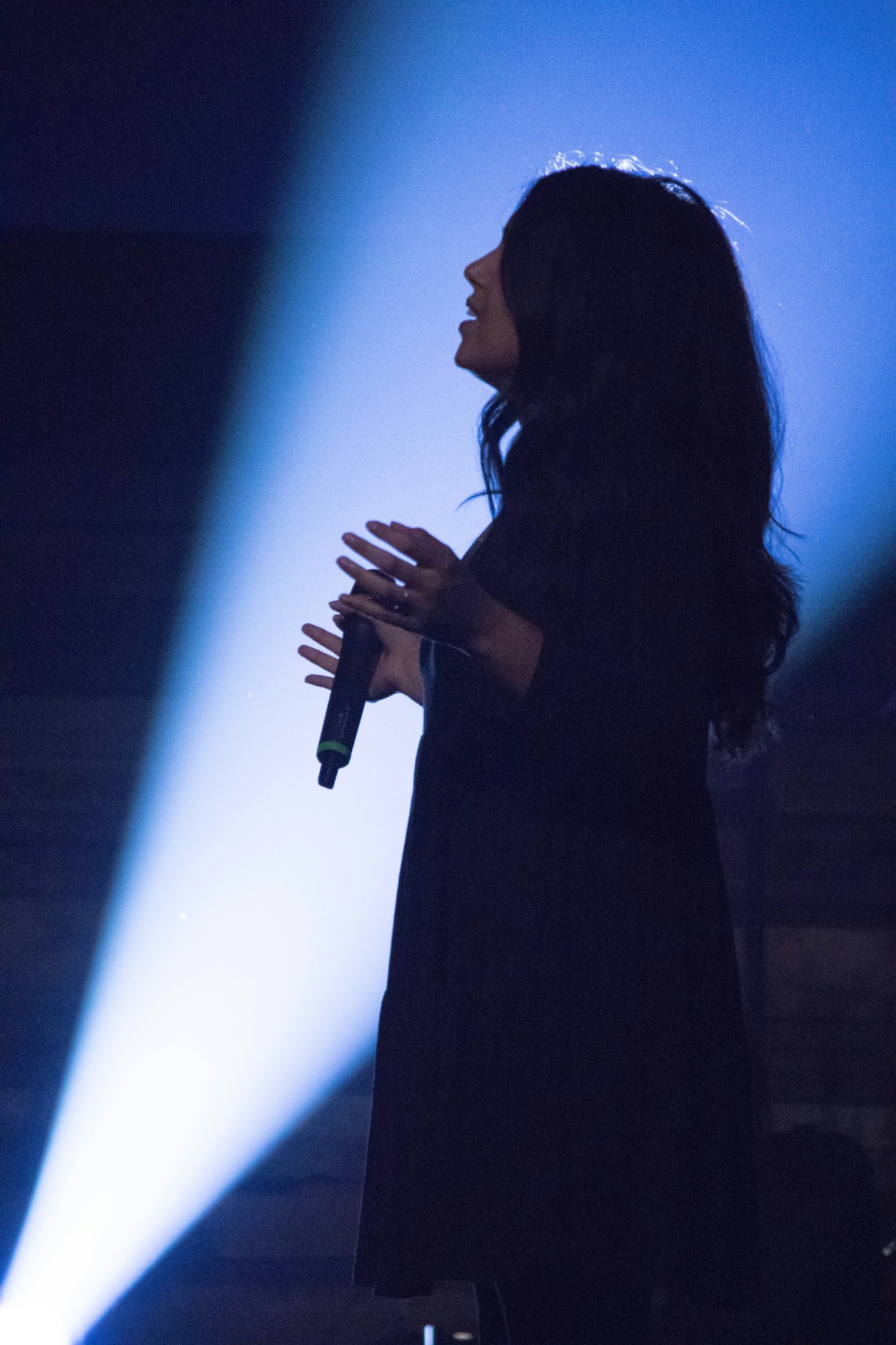 Female singer performing live in blue stage light