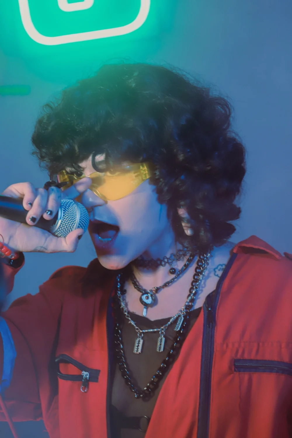 Pop vocalist performing with a microphone in a bold red look