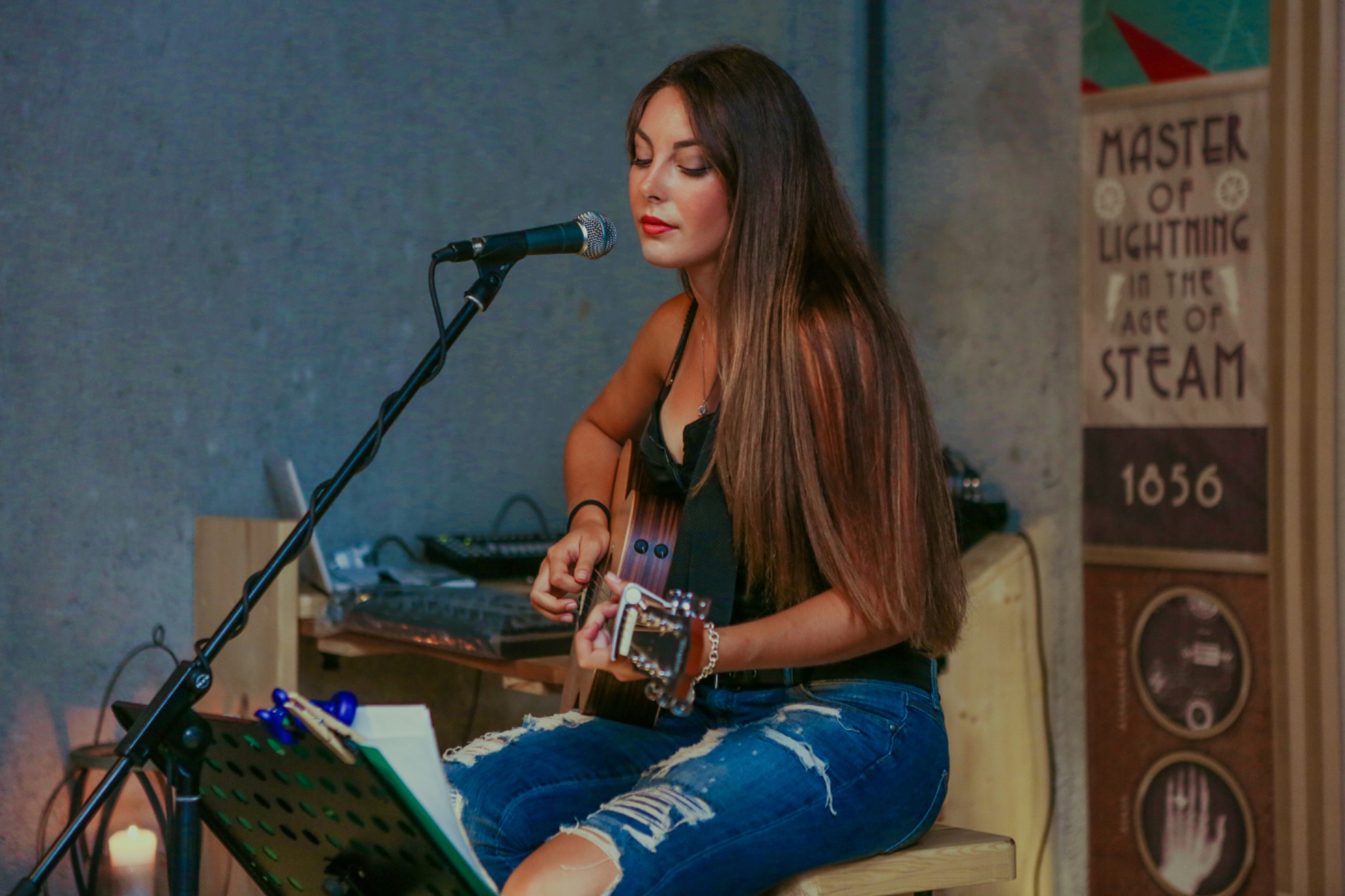 Singer-songwriter performing seated with acoustic guitar