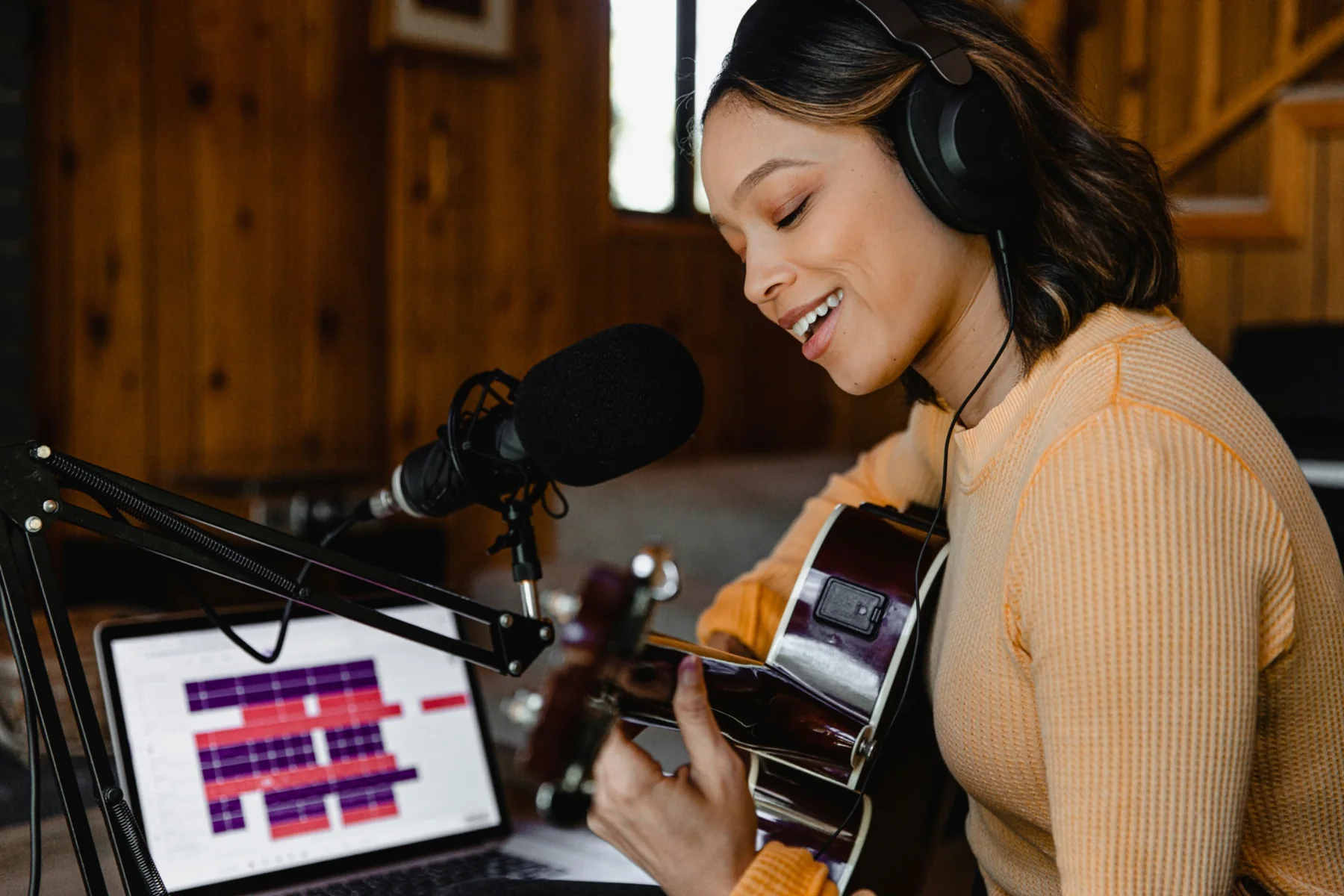 Singer-songwriter recording with guitar and microphone